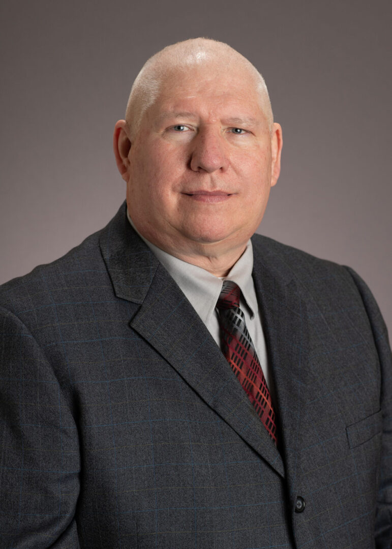 David Barker A man in a suit and tie standing up.