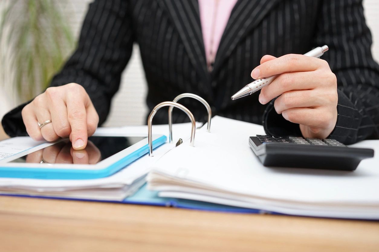 qtq80-teOmSA A person sitting at a table with papers and a tablet.